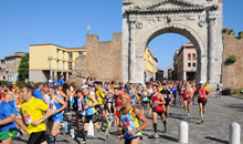 I podisti della StraRimini attraversano l'arco di Augusto